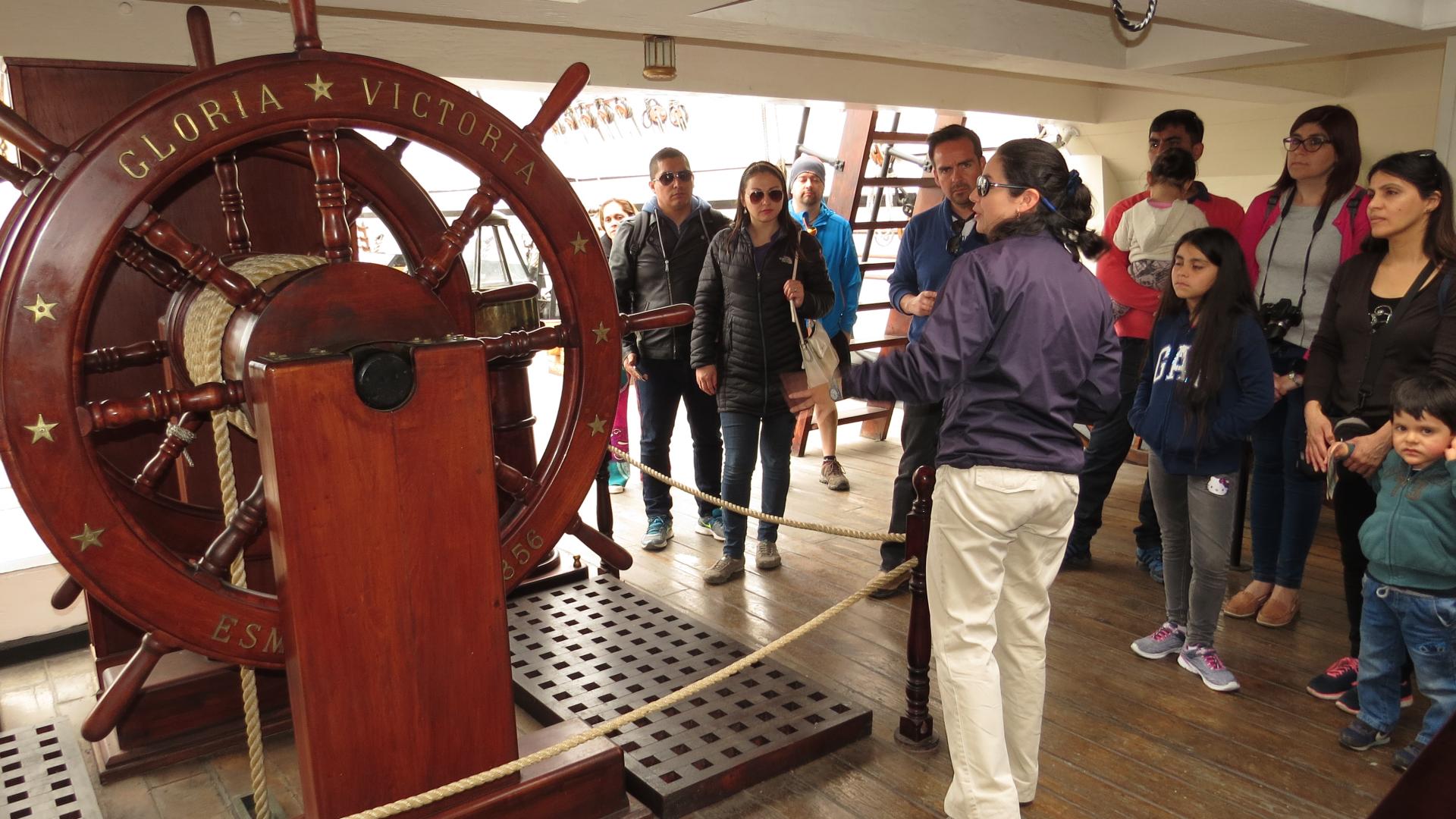 Turistas en tour guiado por la rueda de gobierno