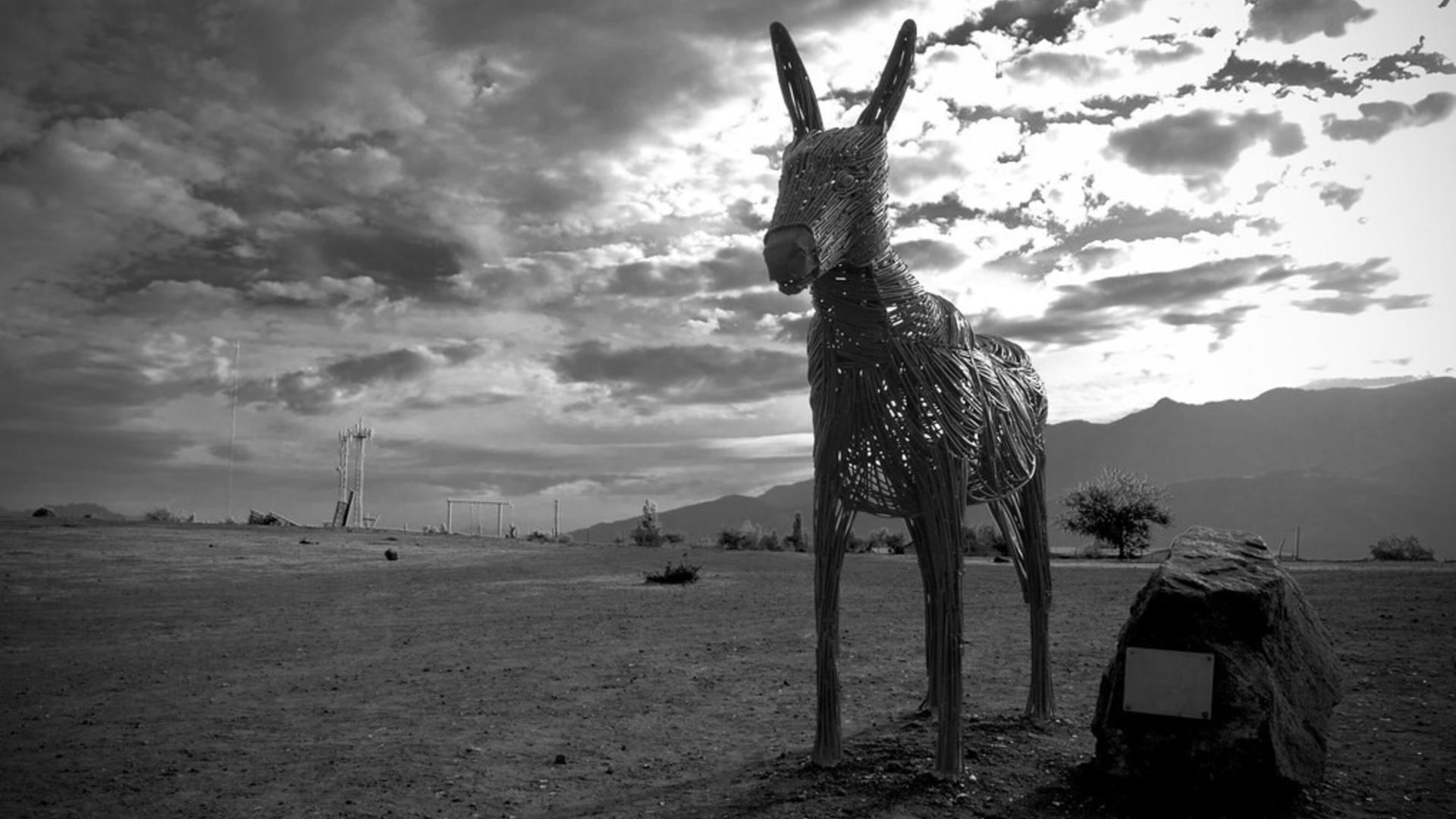 Esta obra representa la figura del burro en forja, simbolizando la conexión entre la tradición rural y el arte contemporáneo, y formando parte de una serie de esculturas que invitan a la reflexión y el disfrute del paisaje
