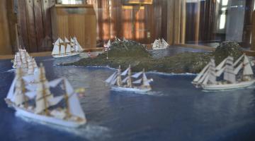 En el centro de la Sala observamos un diorama donde se muestra la importancia del Cabo de Hornos como ruta marítima y la verdadera magnitud de reconocimiento que representa para todo hombre de mar lograr cruzarlo. Esta considera la exhibición de la Regata Bicentenario 